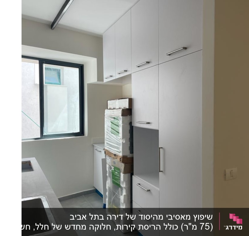 ארונות מטבח לבנים עם ידיות מתכת, חלון גדול